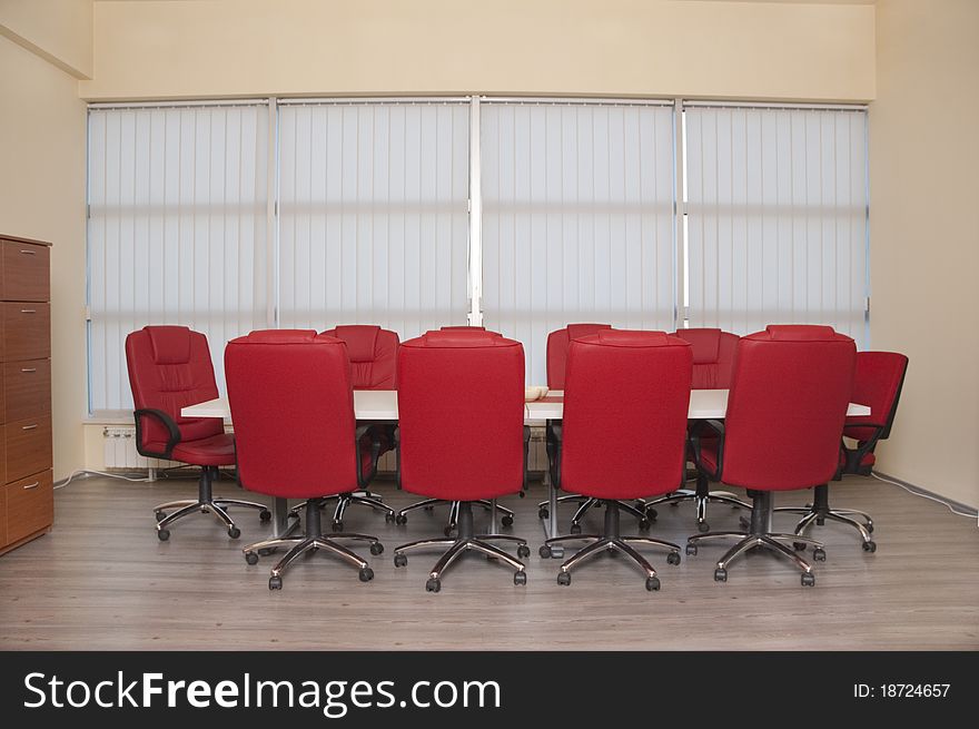 Conference table with a red leather armchair