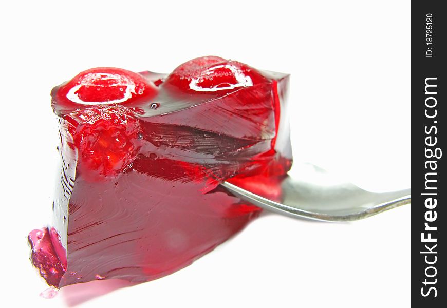 Red marmalade dessert with cherry with spoon inside isolated. Red marmalade dessert with cherry with spoon inside isolated