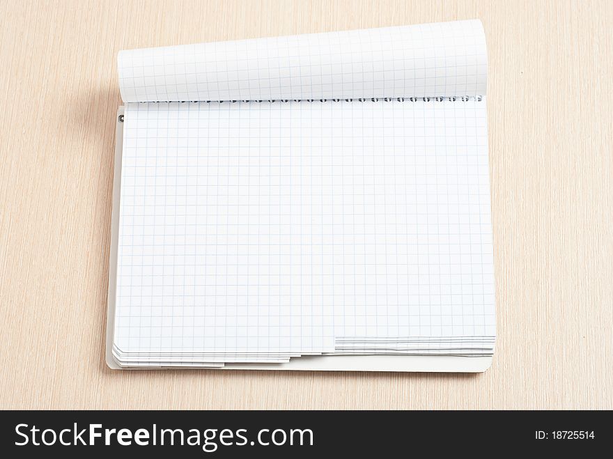 Blank spiral note pad on wood desk