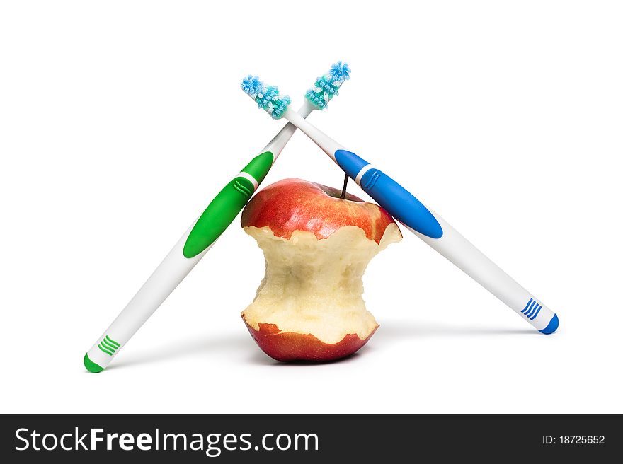 Two toothbrushes and an apple on a white background