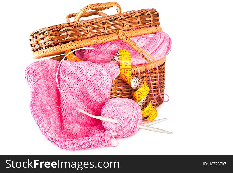 Handmade needle knitted pink canvas, yarn ball and and measuring tape inside basket. Handmade needle knitted pink canvas, yarn ball and and measuring tape inside basket