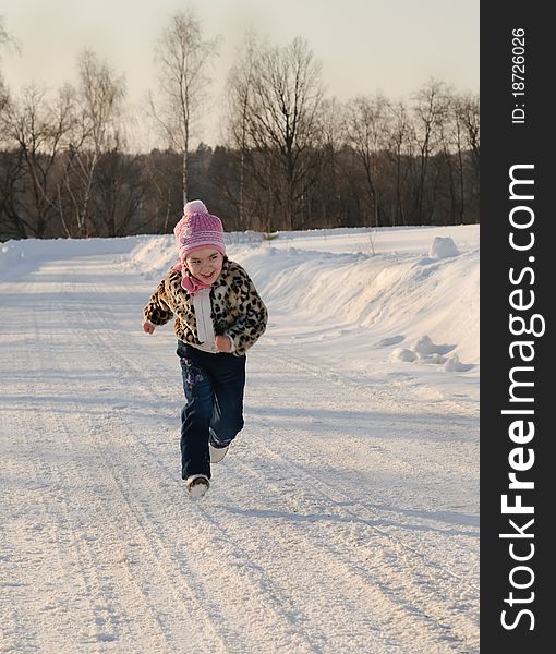 Little girl running through the winter road. Little girl running through the winter road