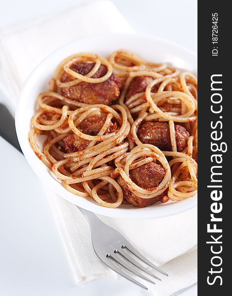 Pasta with meatballs and tomato sauce on white background