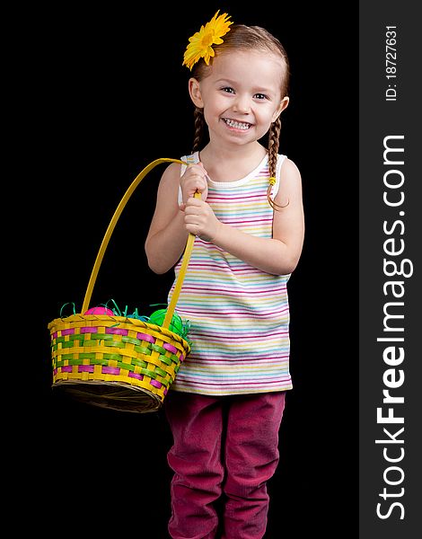 A happy young girl holding her easter basket. She is on the hunt for more eggs.