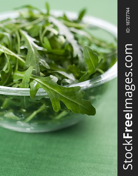 Green rucola fresh salad in glass bowl