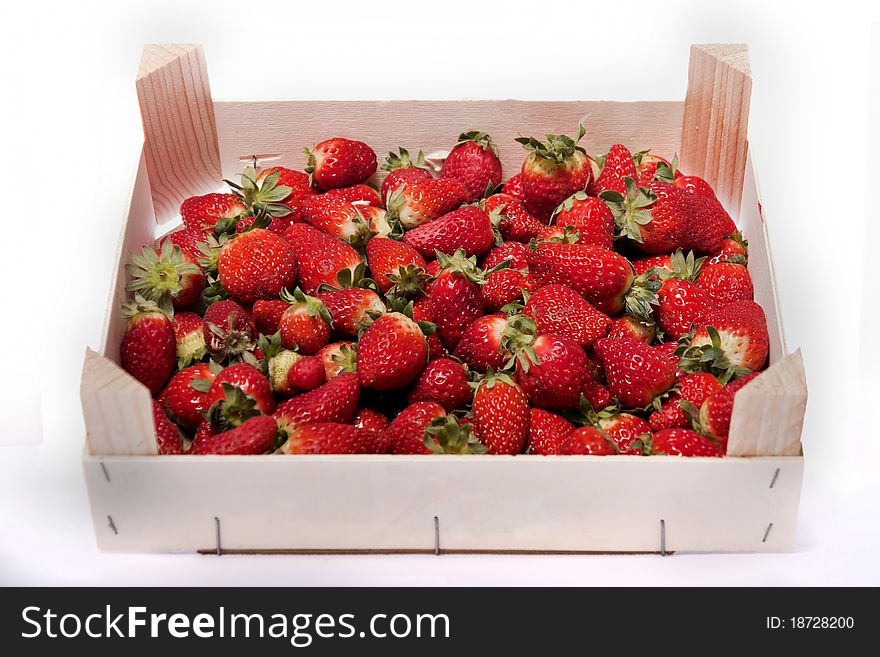 Close view of a wooden box filled with strawberries isolated on a white background. Close view of a wooden box filled with strawberries isolated on a white background.