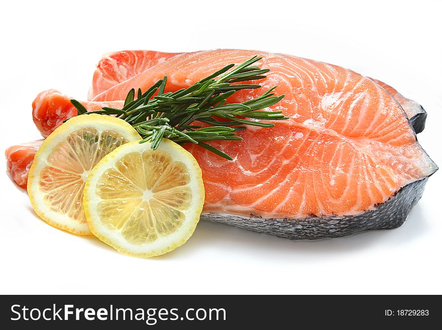 Raw fish meat with lemon and rosemary isolated on a white background. Raw fish meat with lemon and rosemary isolated on a white background