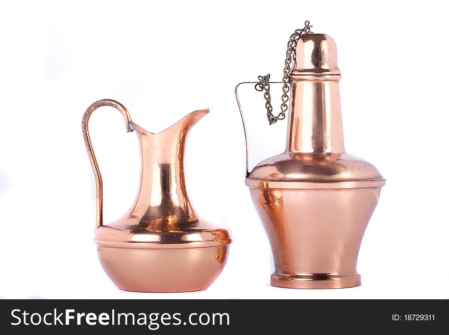 View of two old water recipients made of copper isolated on a white background.