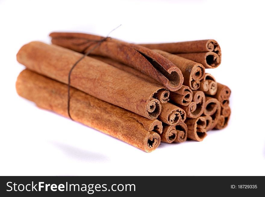 View of a bunch of cinnamon spice quills isolated on a white background. View of a bunch of cinnamon spice quills isolated on a white background.