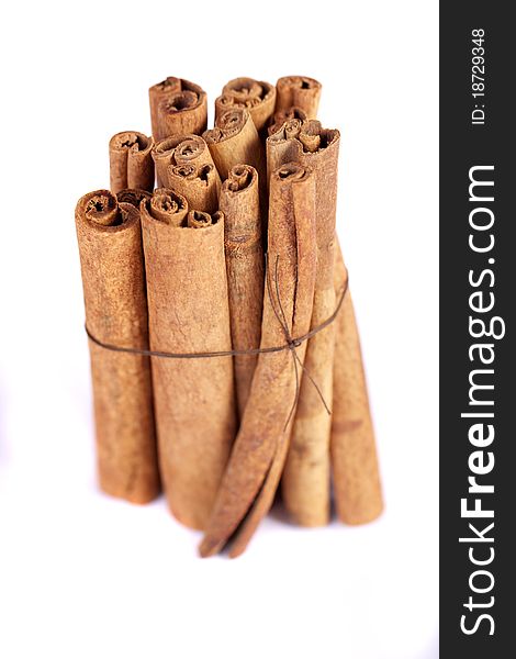 View of a bunch of cinnamon spice quills isolated on a white background. View of a bunch of cinnamon spice quills isolated on a white background.