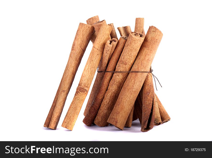 View of a bunch of cinnamon spice quills isolated on a white background. View of a bunch of cinnamon spice quills isolated on a white background.