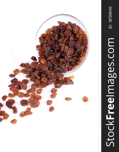 Close view of a pile of dry raisins on a bowl isolated on a white background. Close view of a pile of dry raisins on a bowl isolated on a white background.