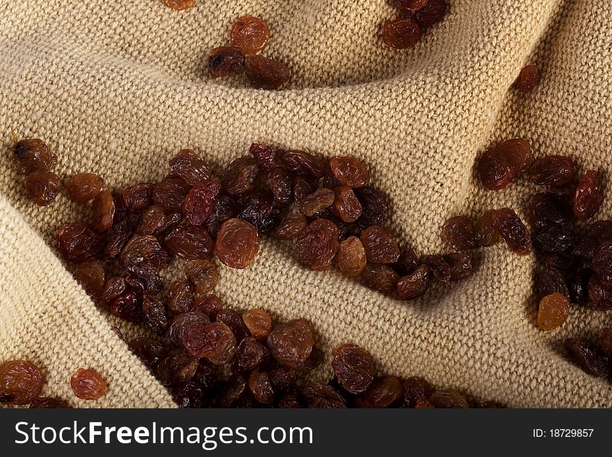 View of a bunch of dry raisins scattered on a cloth.