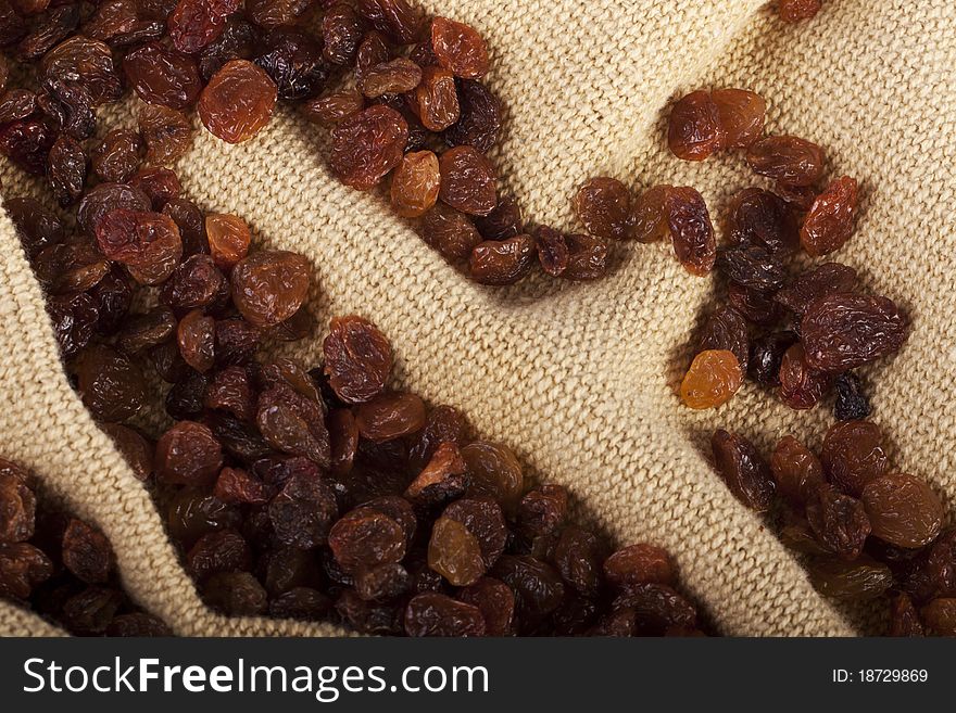 View of a bunch of dry raisins scattered on a cloth.