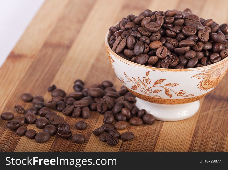 Close view of a bunch of roasted beans of coffee inside a bowl. Close view of a bunch of roasted beans of coffee inside a bowl.