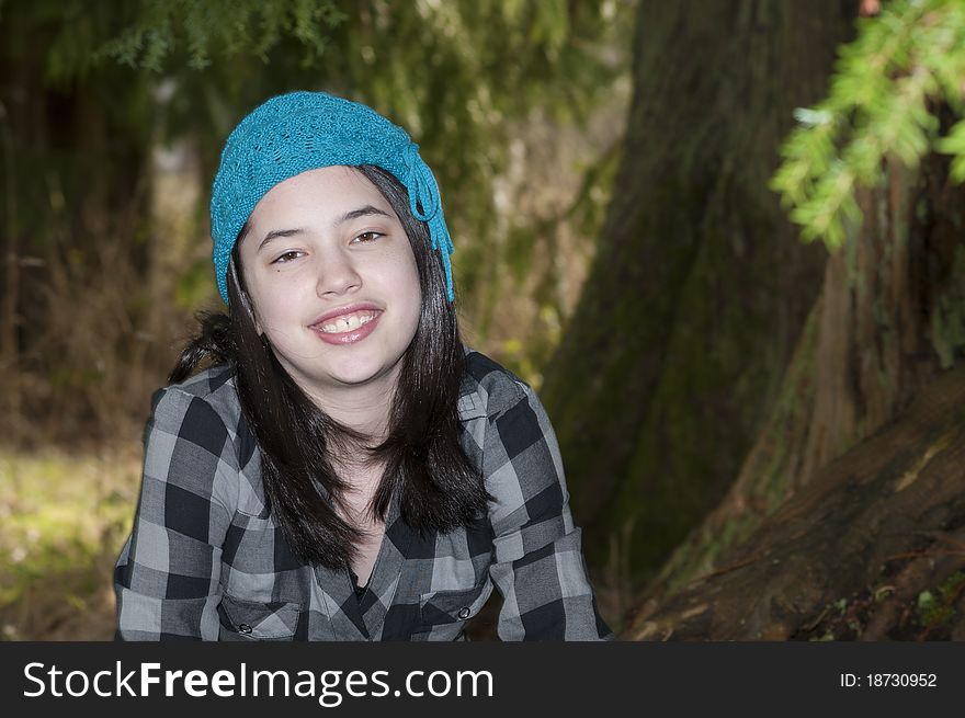 Young preteen girl wearing a flannel shirt in the forest. Young preteen girl wearing a flannel shirt in the forest