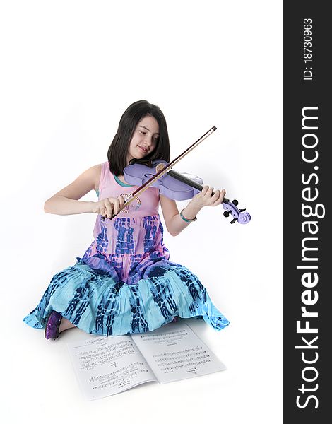 Preteen girl playing a purple violin in tie dye dress. Preteen girl playing a purple violin in tie dye dress