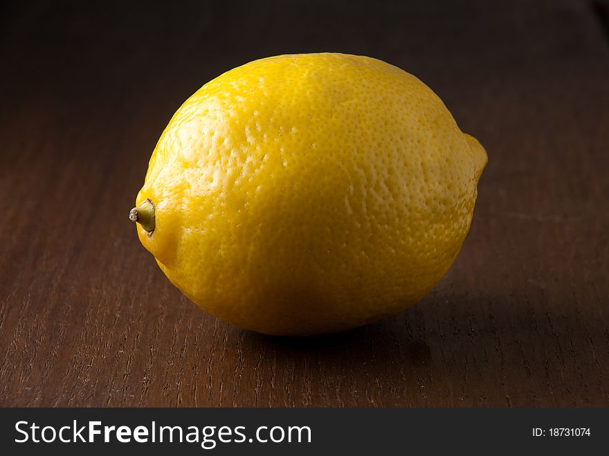 A Single Fresh Yellow Lemon On A Wood Table.