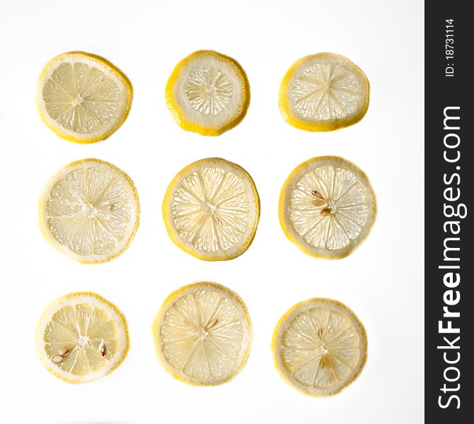 Nine fresh yellow lemon slices with seeds on a white isolated background. Nine fresh yellow lemon slices with seeds on a white isolated background.