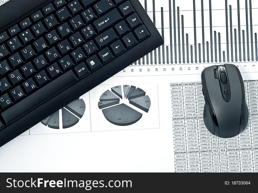 Black keyboard and mouse on a stock chart. Black keyboard and mouse on a stock chart.