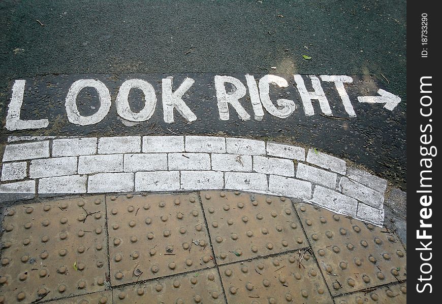 Painted white road sign, reminding pedestrians to look right before crossing the road. Painted white road sign, reminding pedestrians to look right before crossing the road.