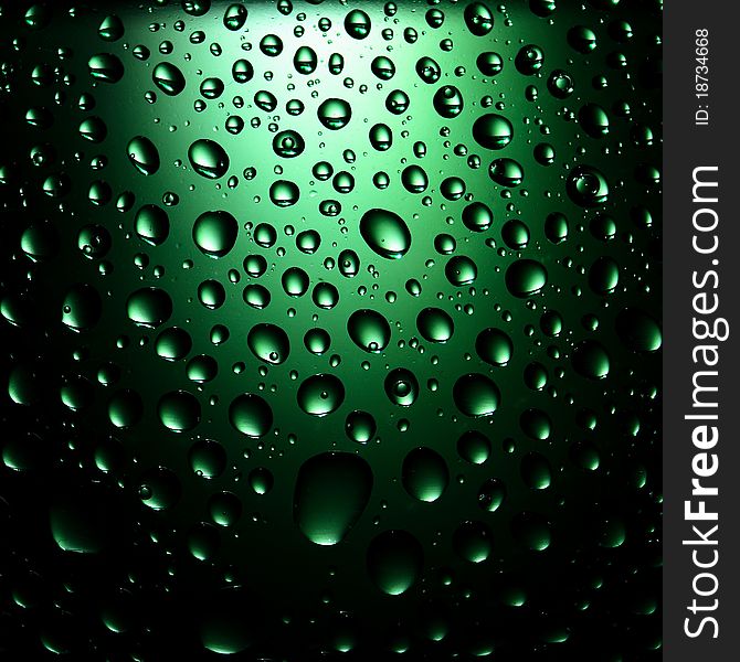 Round water drops on green background close-up. Round water drops on green background close-up