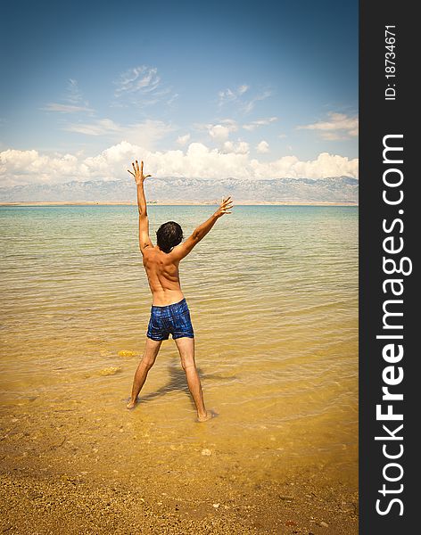 Young happy man at the beach