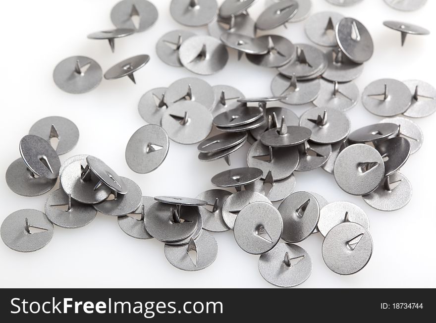 Scattered thumbtacks on a white background. Scattered thumbtacks on a white background.