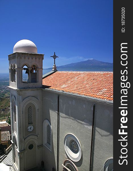 Sicilian Church with Bell Tower showing Mount Etna smoking in background. Sicilian Church with Bell Tower showing Mount Etna smoking in background