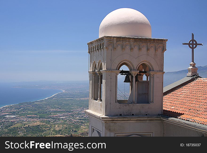 Sicilian Church with close up of Bell Tower with coastline in background. Sicilian Church with close up of Bell Tower with coastline in background