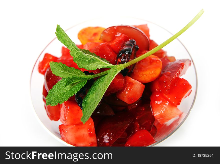 Fruit dessert with green mint on white background