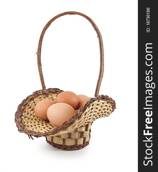 Easter eggs in brown basket on a white background