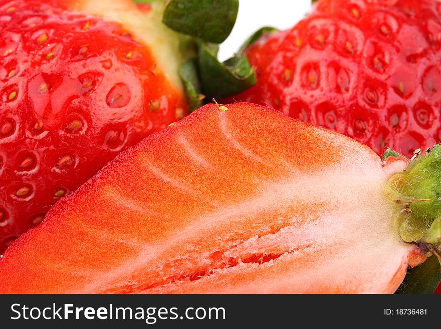 A closeup of slice of strawberry and whole fruits. A closeup of slice of strawberry and whole fruits.
