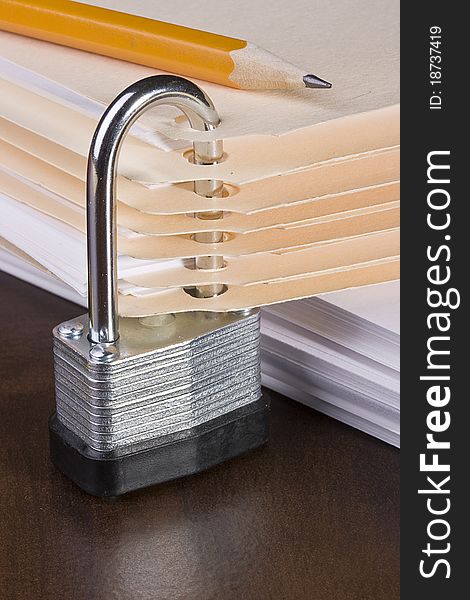 Stack of manila folders closed with a metal lock. Stack of manila folders closed with a metal lock.