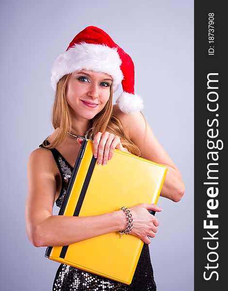 Pretty girl in Santa hat holding a laptop