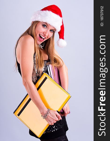 Pretty girl in Santa hat holding a laptops