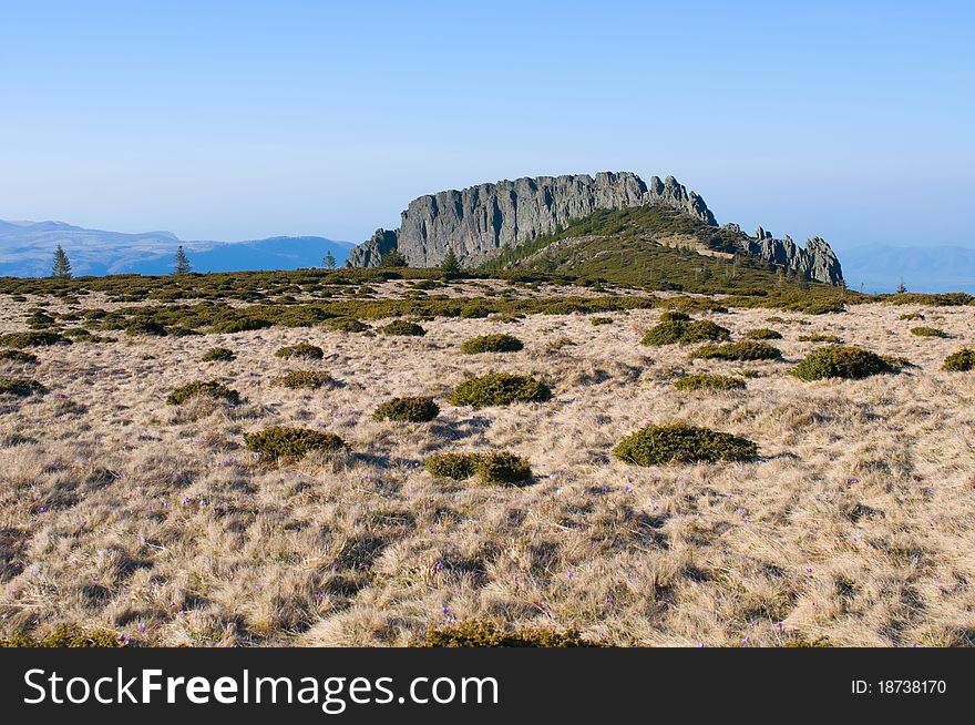 Landscape of stone cliff, blue sky and mountain brown meadow. Landscape of stone cliff, blue sky and mountain brown meadow.