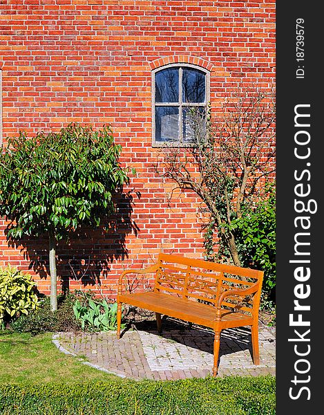 Natural wood bench, red wall and small window