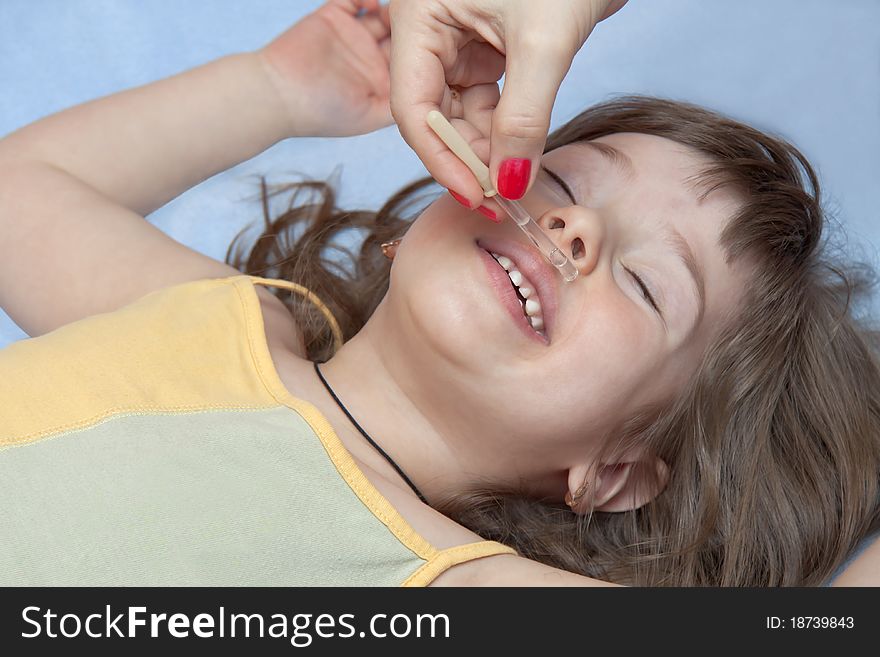 The child lays on a back blindly and mum digs in a nose. The child lays on a back blindly and mum digs in a nose