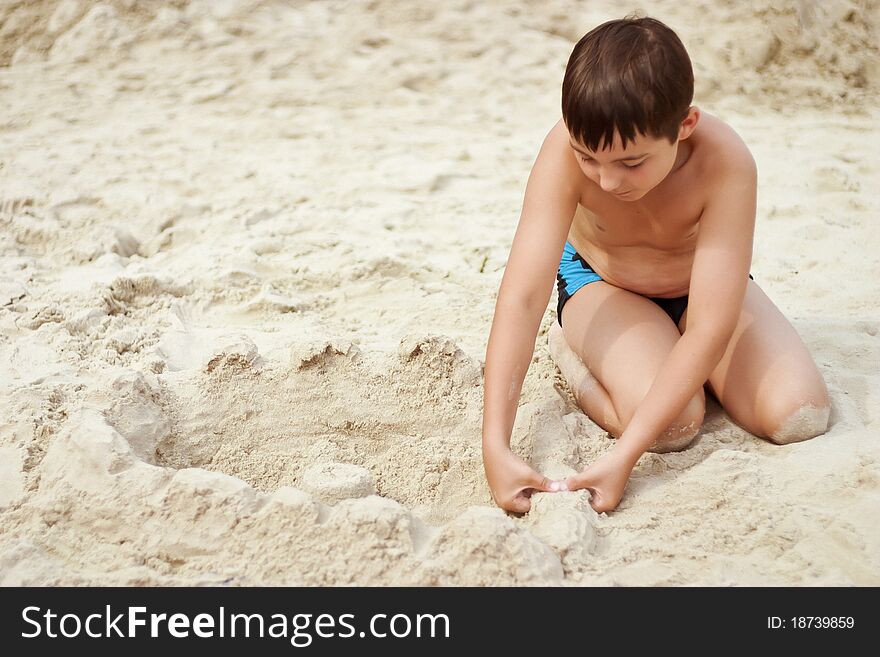 Young boy building a sand castle on the beach