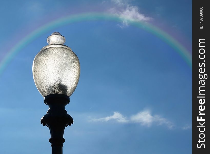 Lamppost with Rainbow against blue sky