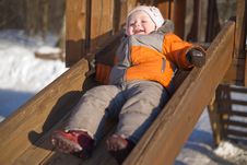Adorable Baby Sliding From Wood Slide In Park Royalty Free Stock Images