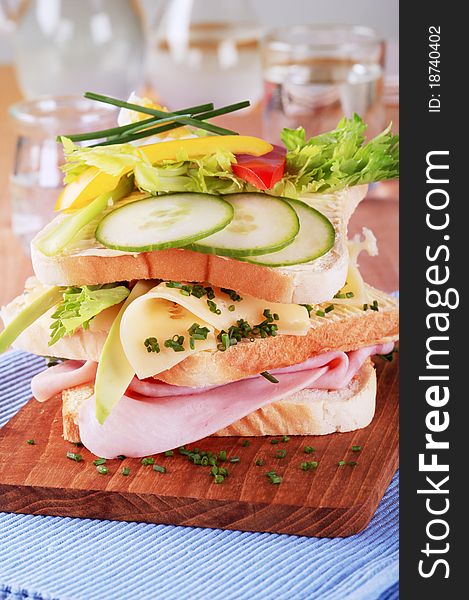 Ham and cheese sandwich garnished with fresh vegetables