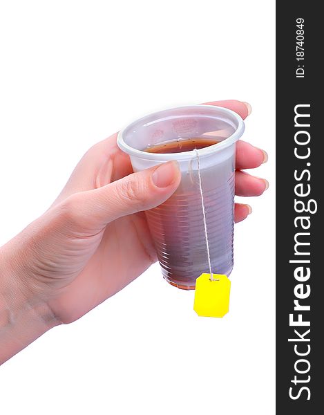 Disposable glass with tea in a hand on a light background