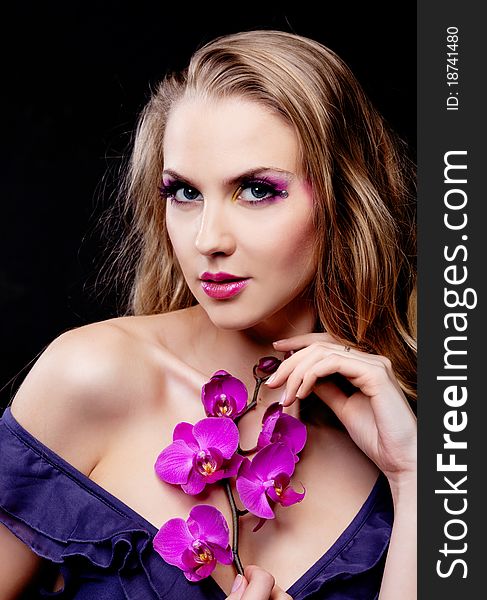 Beautiful young woman with luxurious long curly hair and an orchid. Beautiful young woman with luxurious long curly hair and an orchid
