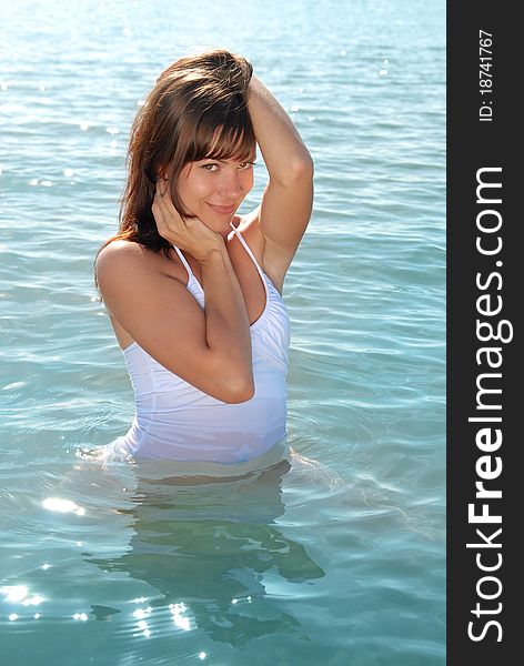 A beautiful young girl smiling sweetly. The girl in the water at the beach. Girl flirts. A beautiful young girl smiling sweetly. The girl in the water at the beach. Girl flirts.