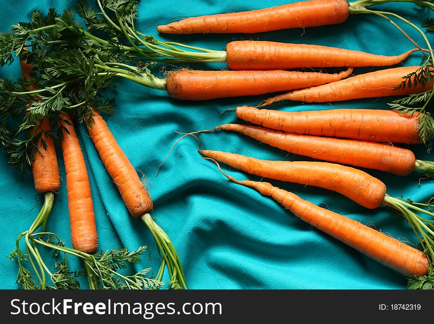 Fresh carrots on blue background.