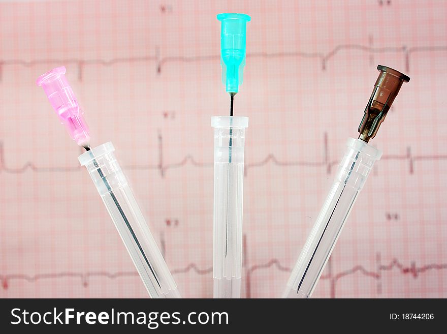 Photo of three medical needles on the background ECG. Photo of three medical needles on the background ECG