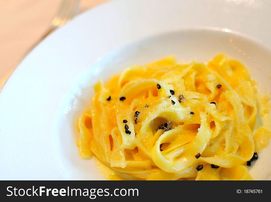 Delicious Italian pasta with cream sauce in white plate.
