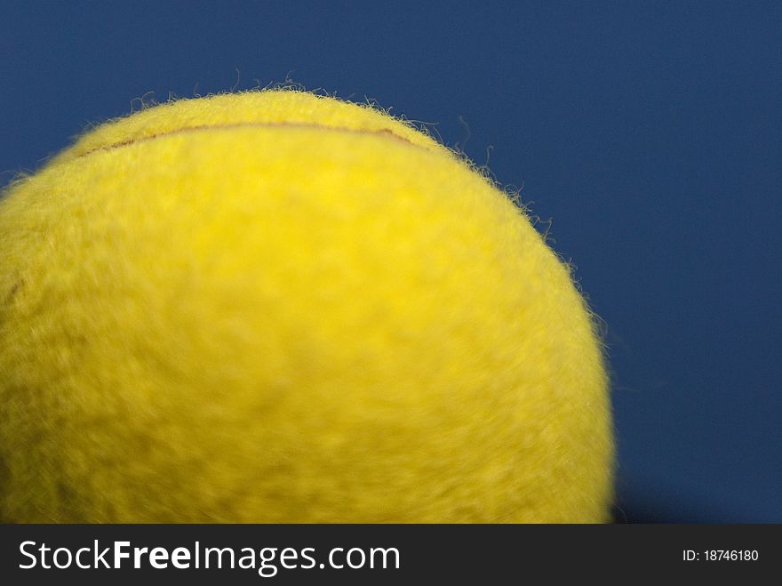 Close-up yellow tennis ball with focus on a small part. Sky blue and copy space. Close-up yellow tennis ball with focus on a small part. Sky blue and copy space.